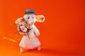 White, knitted mouse with a bouquet of flowers in his paw, in a plaid cap. The symbol of the two...
