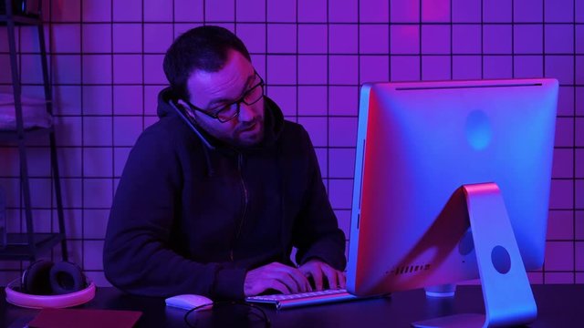 Professional hacker using mobile cell phone talking and spreading bad data virus online.