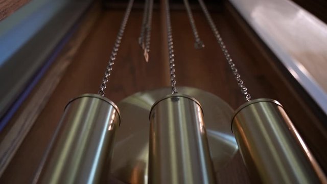 Grandfather clock pendulum slowly swinging.