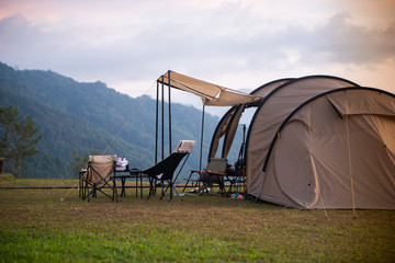 The big tent on the green hill with mountain background © thanarak
