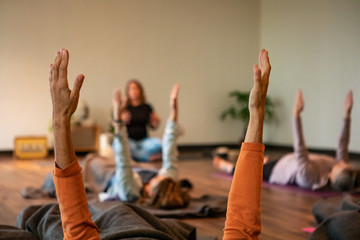 High angled photograph of adult female lying on the floor on top of a yoga mat to practice mindfulness and yoga 