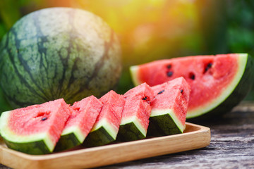 Fresh watermelon slice on wooden plate - Fruit of watermelon half on nature green background