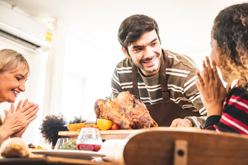 Thanksgiving Celebration Tradition Family Dinner Concept.family having holiday dinner and cutting turkey.Young black adult woman and her daughter happy.