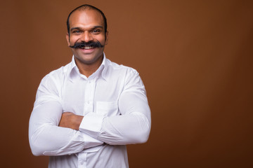 Portrait of happy Indian businessman with mustache in casual clothing