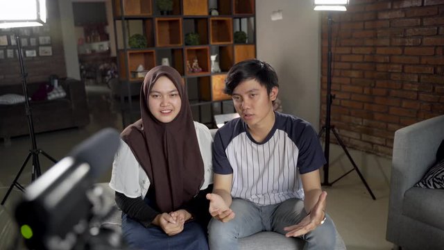 Asian muslim couple blogger recording vlog talking to camera when work at home