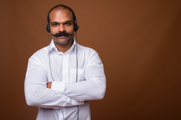 Fototapeta premium Portrait of Indian businessman with mustache as call center representative