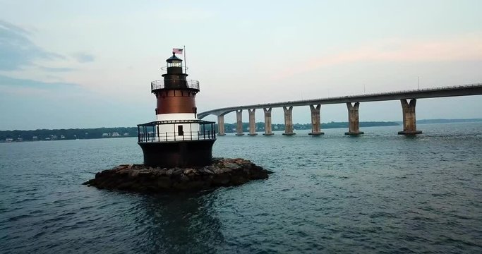 Flying past an ocean lighthouse with bridge
