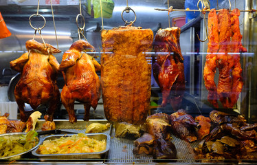 Cooked chickens and pork on display at a local food market