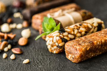 Bunch of mixed gluten free energy bars with dried fruit & various nuts, wooden background. Healthy vegan super food, different fitness diet snacks for sporty lifestyle. Top view, copy space.