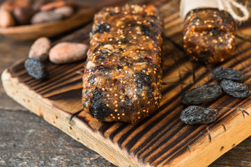 Bunch of mixed nuts bars with dried fruit & various nuts, wooden background. Healthy vegan super food, different fitness diet snacks for sporty lifestyle. Top view, copy space.