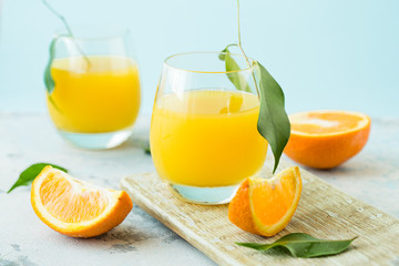 Obraz na płótnie Canvas Glass of fresh orange juice,ripe orange fruit and slices on natural .Freshly squeezed orange juice with drinking straw,orange fruit and orange slices.