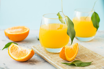 Glass of fresh orange juice,ripe orange fruit and slices on natural .Freshly squeezed orange juice with drinking straw,orange fruit and orange slices.