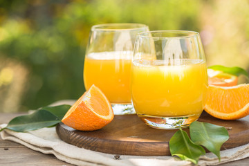 Fototapeta na wymiar Glass of fresh orange juice,ripe orange fruit and slices on natural .Freshly squeezed orange juice with drinking straw,orange fruit and orange slices.