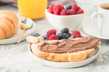 breakfast with croissants and berry, orange juice. fresh crispy croissants and coffee on a light background, top view/