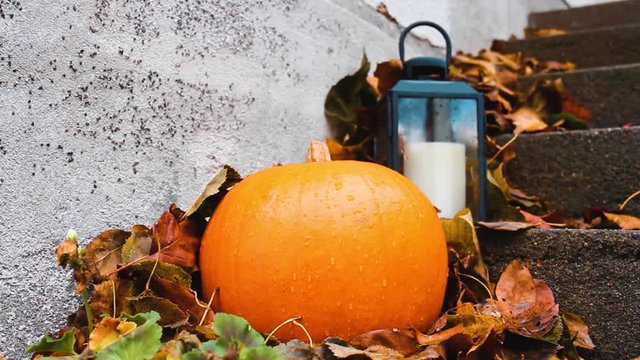 Halloween pumpkin and small lantern outside porch