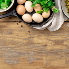 Healthy breakfast top view with ingredient for cooking. Green peas, eggs, spinach, parsley and cheese on wooden background with copy space top view