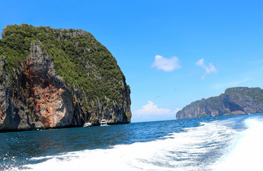 Fototapeta premium boat ride on the sea, exotic James Bond islands against the blue sea, waves of spray in Thailand