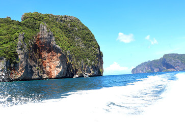 Naklejka premium boat ride on the sea, exotic James Bond islands against the blue sea, waves of spray in Thailand