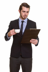 Portrait of young handsome bearded businessman in suit