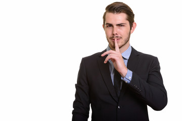 Portrait of young handsome bearded businessman in suit