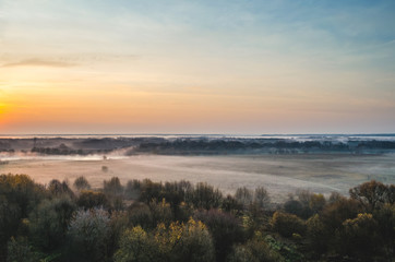 Fototapeta na wymiar Sunrise in autumn. Valley at dawn in fog.