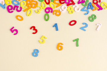 Colored wooden numbers composition on beige background.