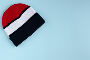 Striped colored hat composition on blue background.