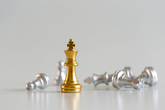 chess game gold king standing and silver background, business strategy concept.