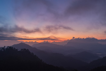 silhouette shot image of mountain and sunset sky in background.