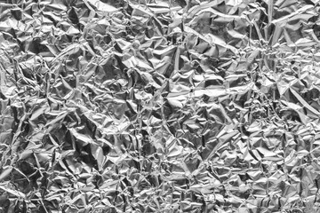 silver leaf foil background with shiny crumpled uneven surface for texture and background