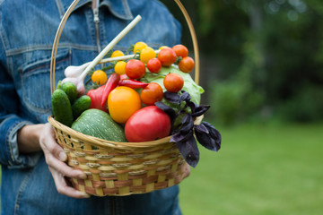 Woman holds a basket with vegetables. Healthy eating.