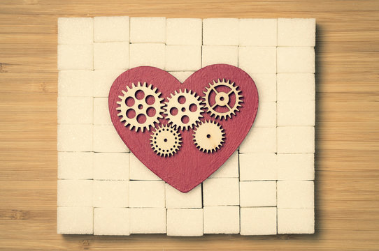 heart and refined sugar on wooden background, tinted image