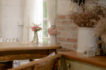 Beautiful flowers in glass vase stand on wooden table with light from window. home decorate in vintage style