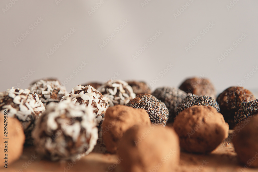 Wall mural Homemade healthy vegan raw sweet balls made of dried fruits and nuts on wooden plate. Diet dessert with no added sugar, healthy diet gluten free food concept. Selective focus.         