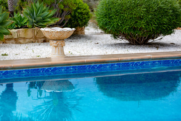 Part of italian-style pool with garden plants by the sea, Cyprus.