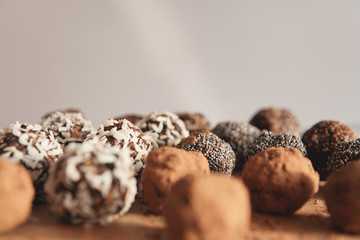 Homemade healthy vegan raw sweet balls made of dried fruits and nuts on wooden plate. Diet dessert with no added sugar, healthy diet gluten free food concept. Selective focus.         