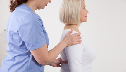 Obraz premium Physiotherapist working with middle aged patient in clinic