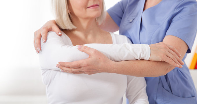 Physiotherapist working with middle aged patient in clinic
