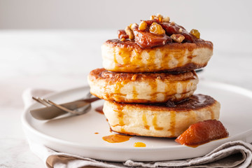 Pancake stacked with maple syrup and apple fruit. Copy space.