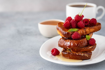 French toasts, French toasts made of sliced brioche with fresh raspberries, honey and mint. Delicious breakfast or dessert