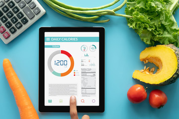 Calories counting , diet , food control and weight loss concept. woman using Calorie counter...