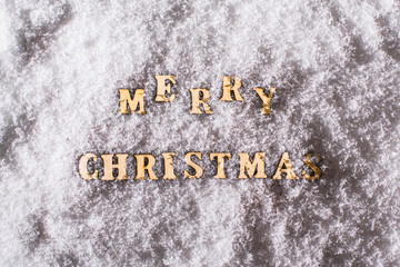 Merry christmas from wooden letters on the night snow. Top view. Winter. Copy space