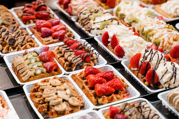 Traditional Belgian street food waffles stuffed in a tourist shop. Background.