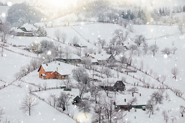 Beautiful rural village in the mountains in wintertime with heavy snow.