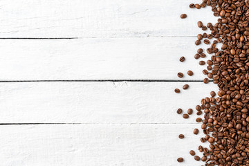 Overhead shot of roasted coffee beans on rustic wooden background with copyspace