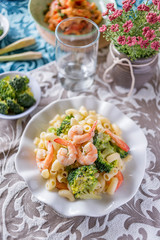 Italian pasta fettuccine in a creamy sauce with shrimp on a plate.