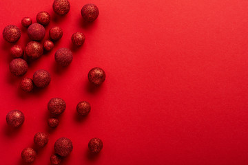 Christmas flat lay background with fir tree, with Christmas tree made of red toys balls decorated golden confetti in red envelope on red background. New year concept. Top view.