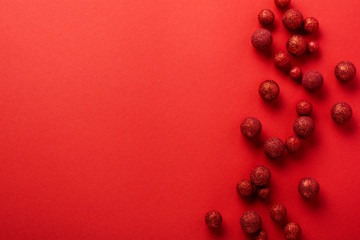 Christmas flat lay background with fir tree, with Christmas tree made of red toys balls decorated golden confetti in red envelope on red background. New year concept. Top view.