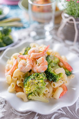 Italian pasta fettuccine in a creamy sauce with shrimp on a plate.