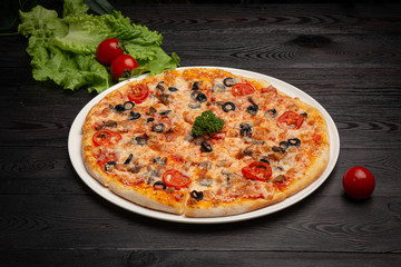 assorted pizza sliced into pieces with cheese, tomato and olives